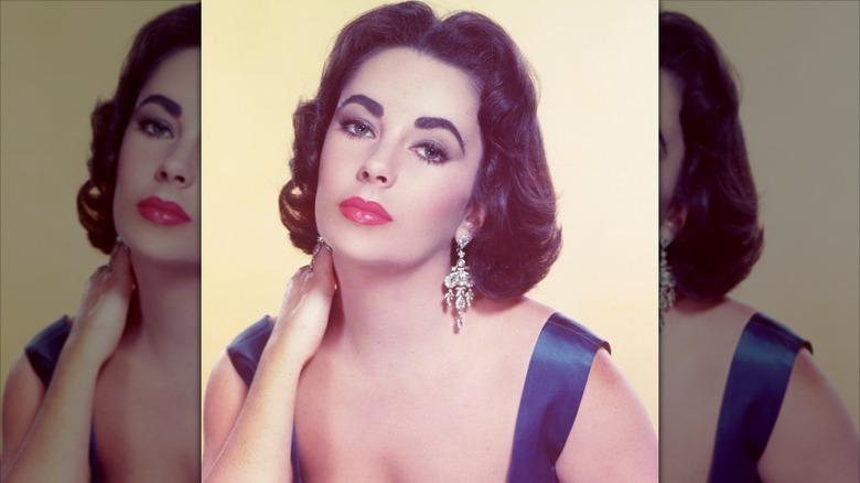 Elizabeth Taylor posing in a studio portrait with diamond earrings