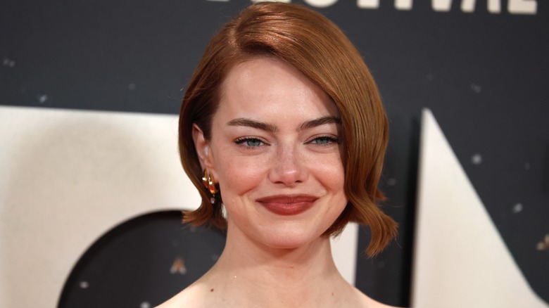 Emma Stone smiling with short auburn bob hair