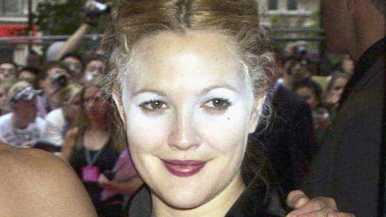 Closeup of Drew Barrymore smiling at event with harsh white powder on her face