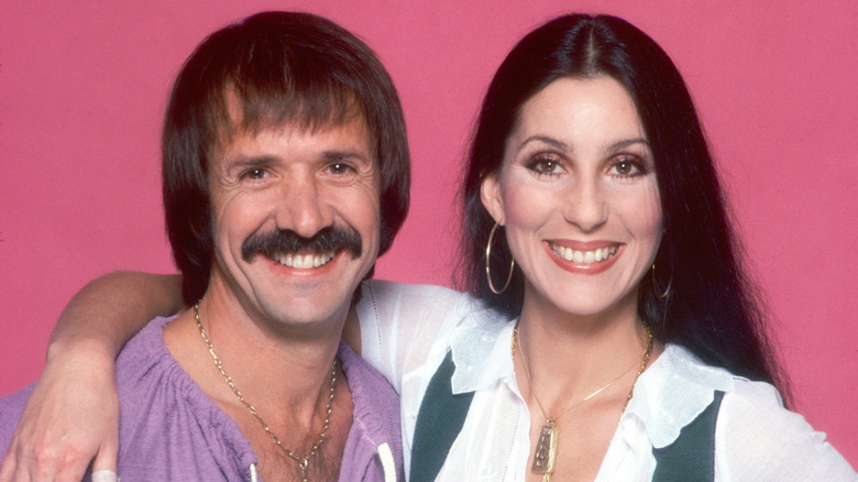 Sonny & Cher posing in front of a pink background
