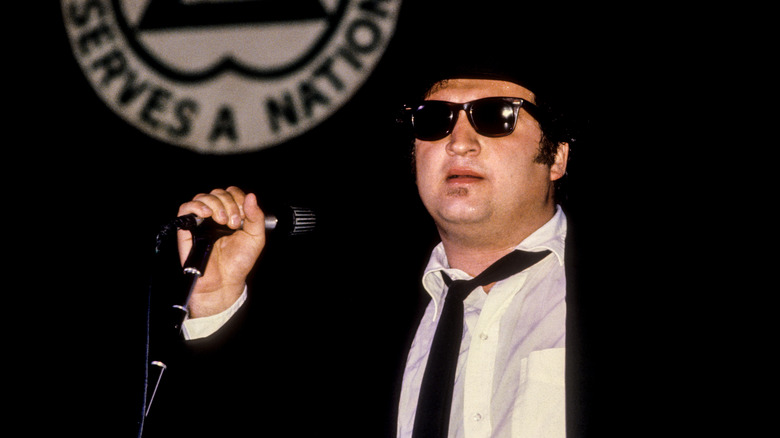 John Belushi on the mic in his classic black tuxedo and sunglasses