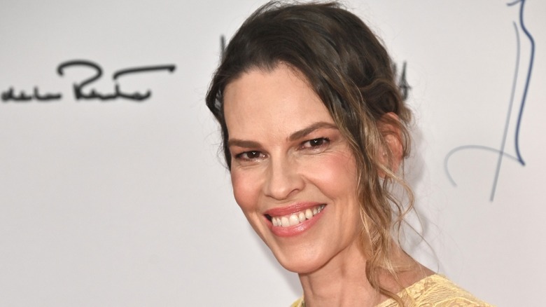 Hilary Swank smiling at a fashion show.