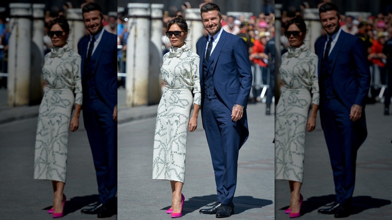 Victoria Beckham poses next to David Beckham