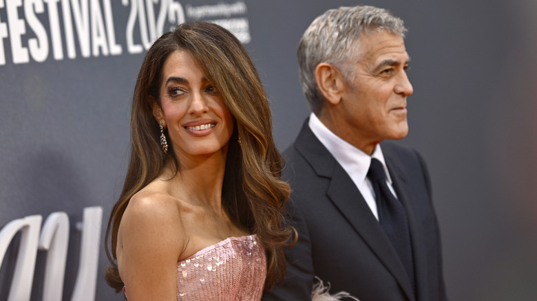 Amal Clooney with side-parted hair and George Clooney in black suit attending the 2025 "Jay Kelly" premiere