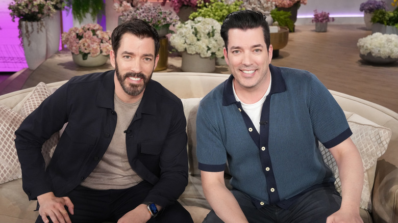 Drew Scott and Jonathan Scott smiling on set of 