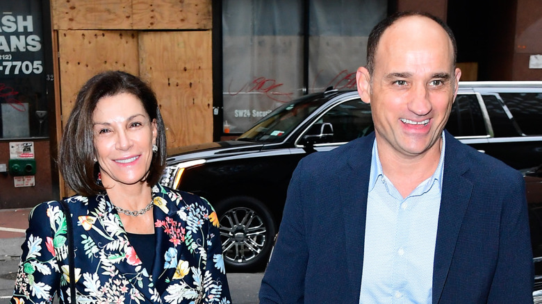 Hilary Farr and David Visentin smiling as they exit car on busy street
