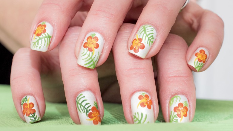 White nails with orange flowers