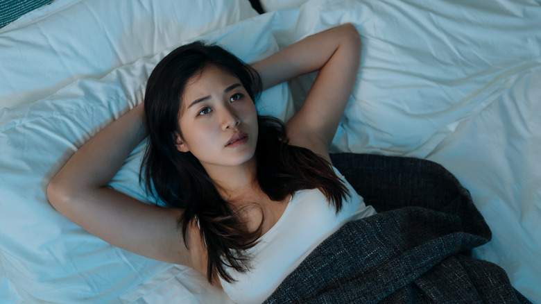 Woman lying in bed looking up