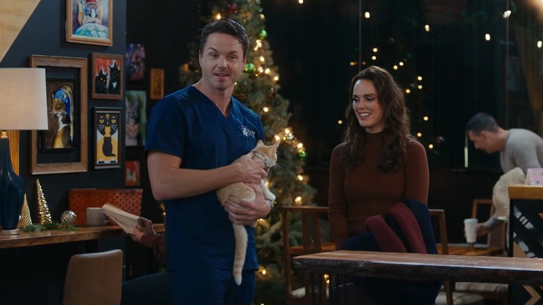 Paul Campbell holding a cat in "Christmas at the Catnip Café"