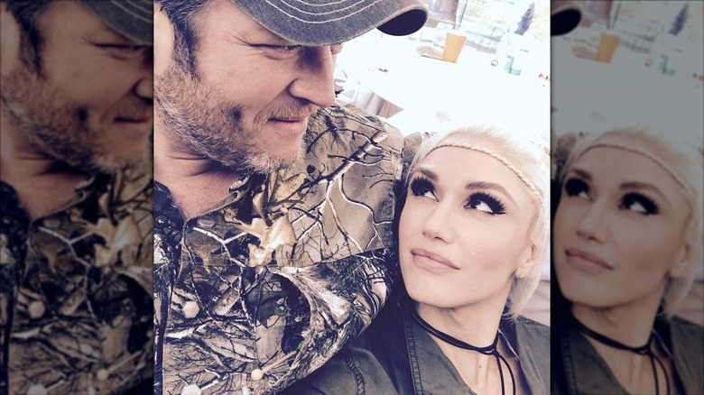 Gwen Stefani gazing up at Blake Shelton, who is looking off to the side and wearing a camouflage shirt