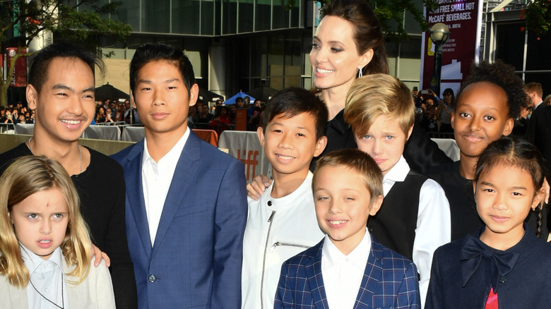 Kimhak Mun, Sareum Srey Moch, Angelina, Maddox, Zahara, Shiloh, Pax, Vivienne, and Knox Jolie-Pitt smiling at the premiere of  "First They Killed My Father" in 2017