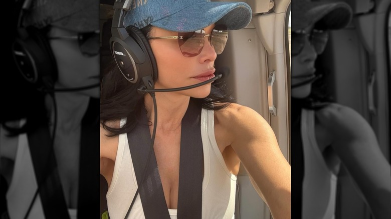 Lauren Sánchez wearing a pilot headset and looking out of a window