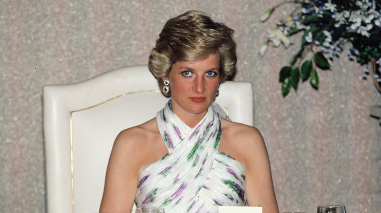 Princess Diana looking haunted in a halter neck white dress