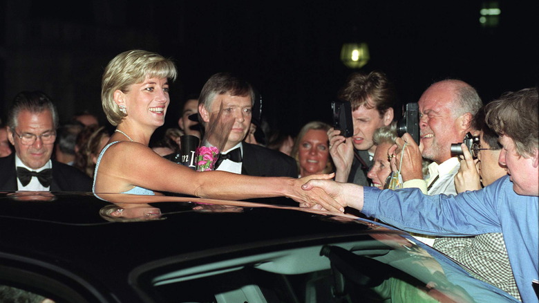 Crowd of photographers surrounding Princess Diana near her car