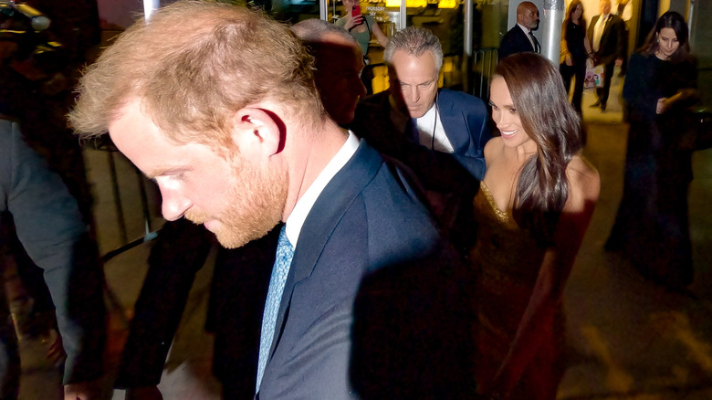 Prince Harry and Meghan Markle escorted by their security team
