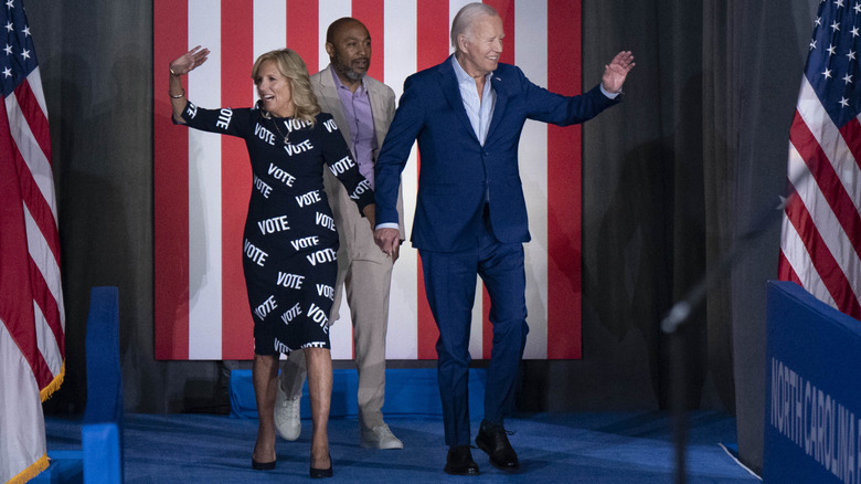 First Lady Jill Biden, with "VOTE" printed on her dress, and U.S. President Joe Biden wave as they arrive at a post-debate campaign rally on June 28, 2024