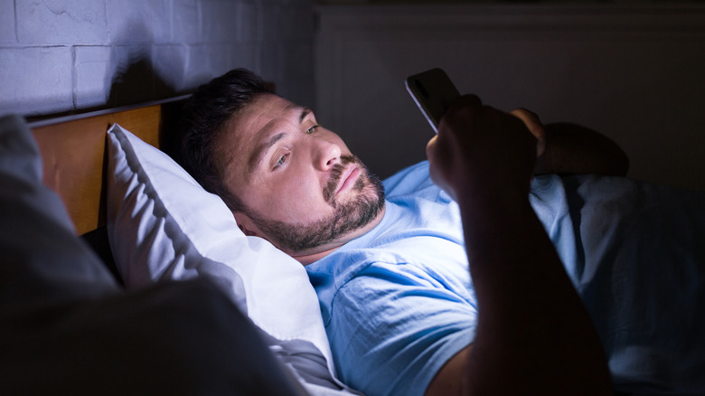 Man texting in bed at night