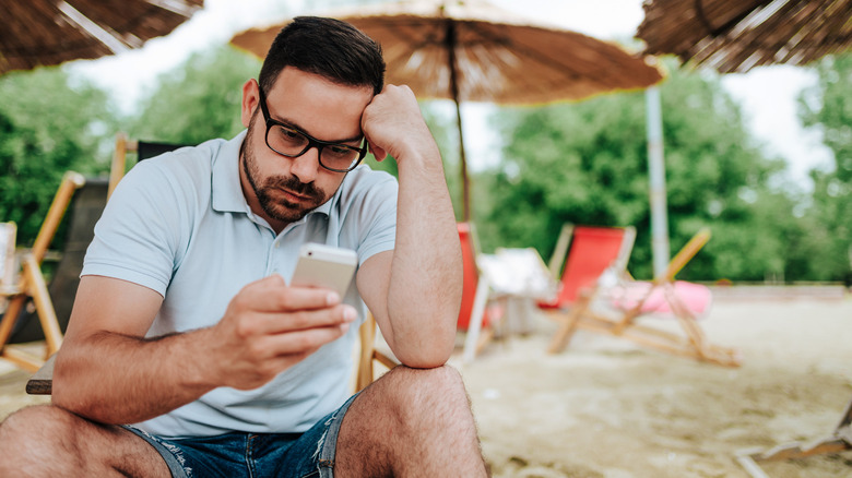 Annoyed man looking at phone