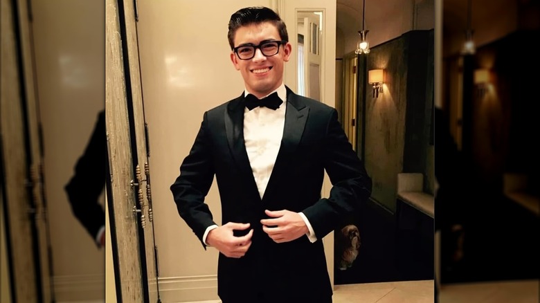 Smiling Michael Consuelos wearing glasses and a tuxedo.