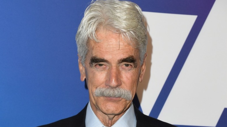 Sam Elliott posing on the red carpet at the Oscar nominees luncheon in 2019