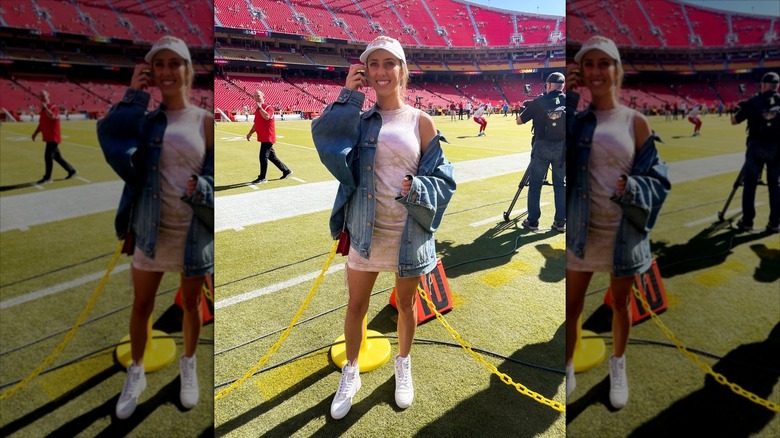 Brittany Mahomes fixing her hair and smiling on the side lines.