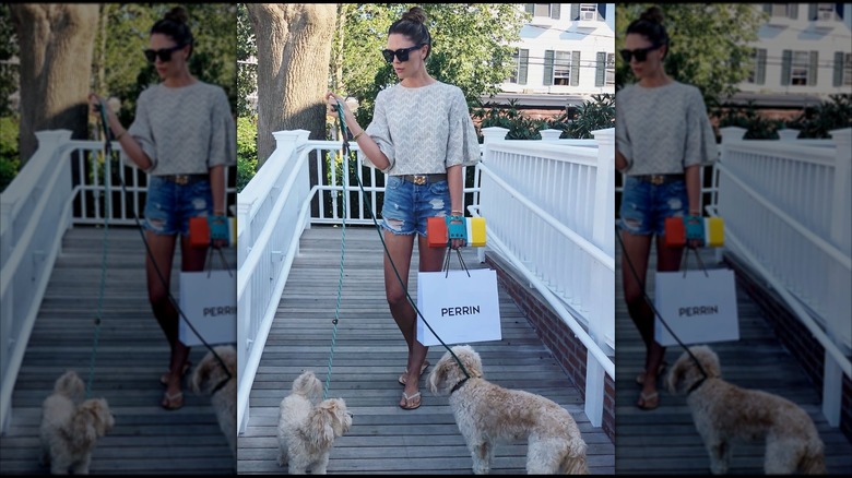 Bettina Anderson holds a shopping and a pair of leashes while walking with two dogs in this photo posted on Instagram in August 2018 (2018)