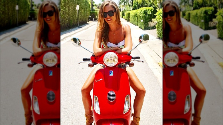 Bettina Anderson smiles while sitting on a parked scooter in this photo posted in October 2018 (2018)