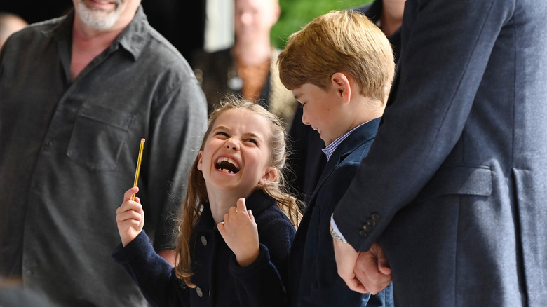 Princess Charlotte laughs as she shares a look with Prince George