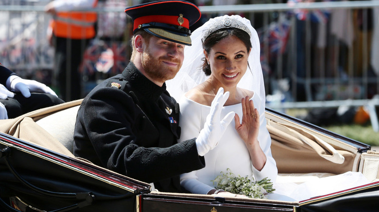 Prince Harry and Meghan, Duchess of Sussex, waving at crowds following their wedding