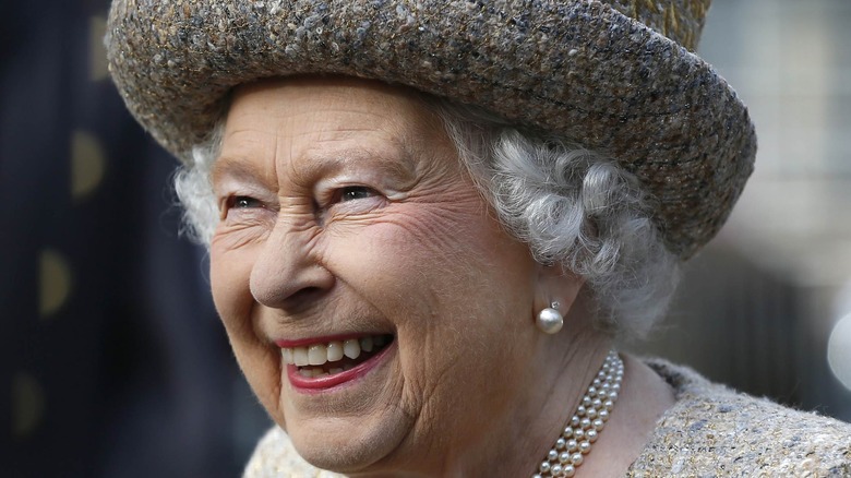 Queen Elizabeth II laughing in a little hat