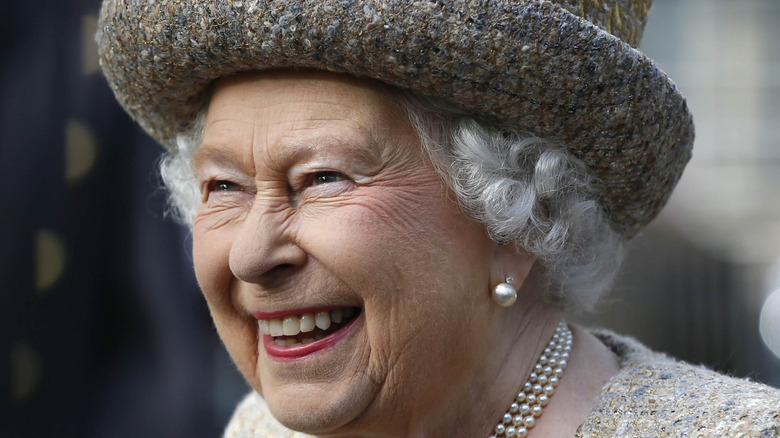 Queen Elizabeth II laughing in a little hat