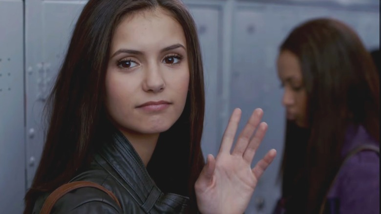 Nina Dobrev as Elena Gilbert, waving her hand in "The Vampire Diaries."
