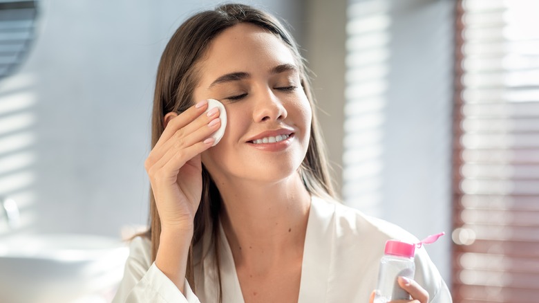 Woman using toner with cotton