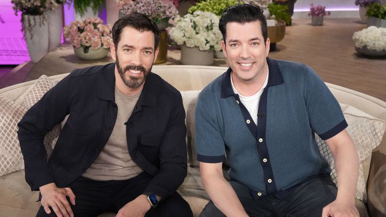 The Property Brothers, Jonathan and Drew Scott, sitting on a couch together