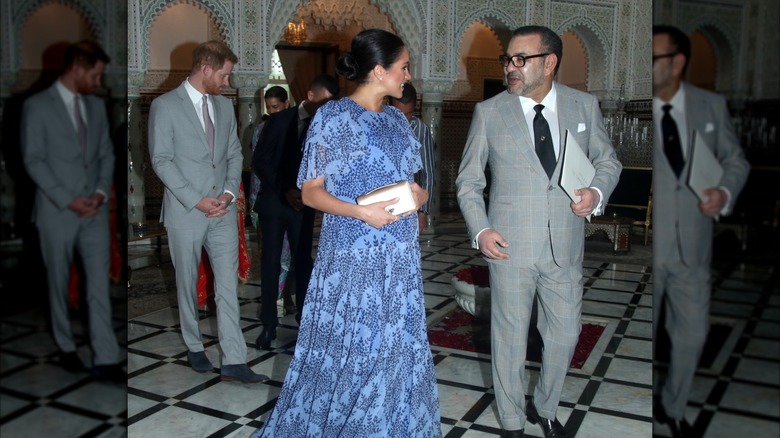 Meghan Markle speaking with the King of Morocco while Prince Harry walks behind