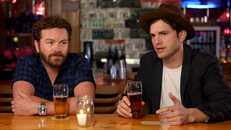 Danny Masterson and Ashton Kutcher talking over beers at a bar