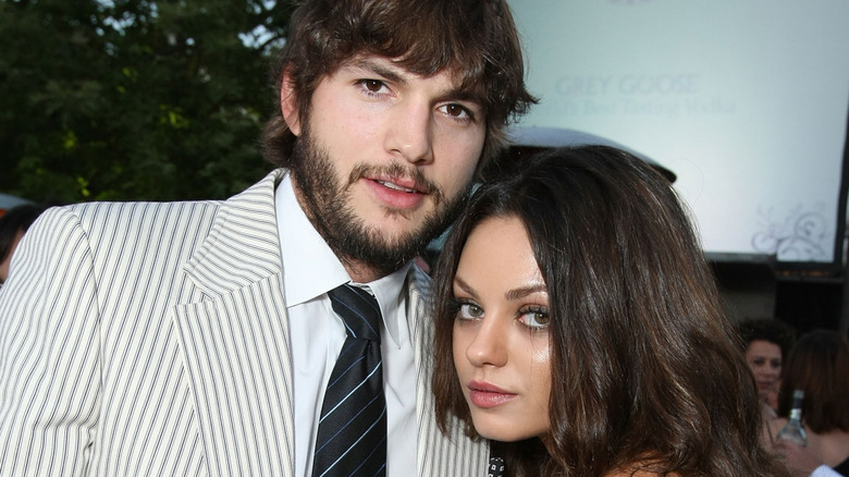 Close-up of Aston Kutcher and Mila Kunis posing closely together