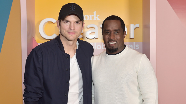 Ashton Kutcher and Sean Combs smiling at event