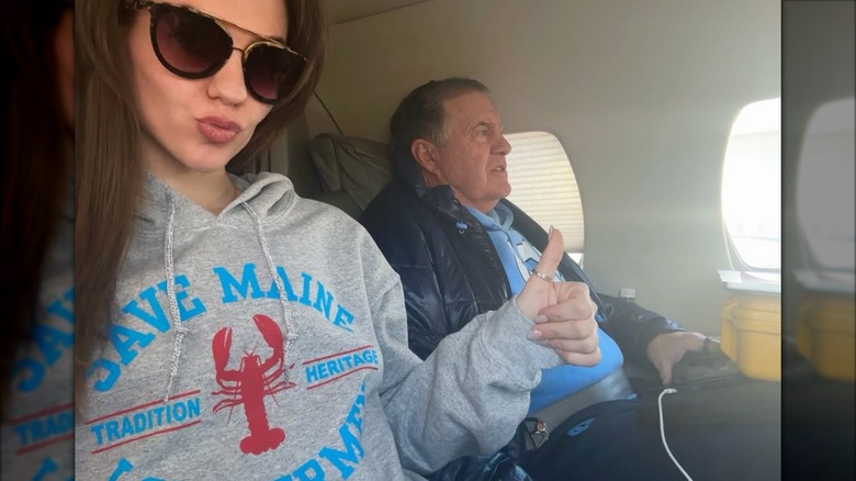 Jordon Hudson giving a thumbs up while taking a selfie with Bill Belichick on a flight