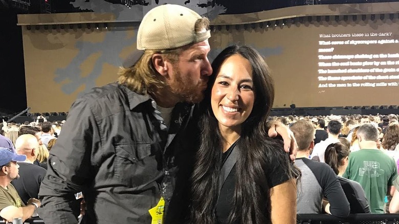 Chip Gaines kissing Joanna Gaines on side of the the head at a U2 concert