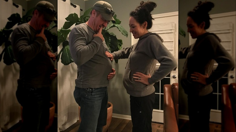 Joanna Gaines placing her hand on Chip Gaines belly and smiling