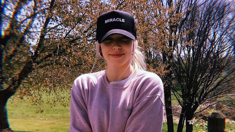Alex Cooper smiling outside her parents house in July 2020