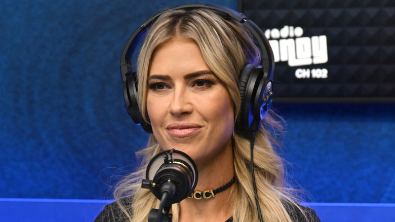 Christina Haack in front of a microphone with headphones on