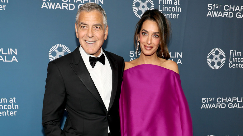 George Clooney and Amal Clooney posing on step-and-repeat