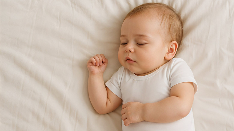 Photo of a sleeping baby on a beige blanket.