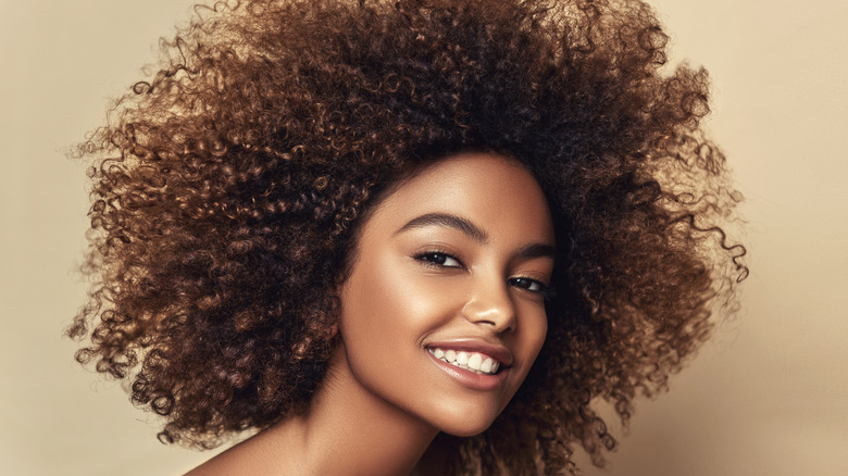 Woman with curly natural hair, smiling