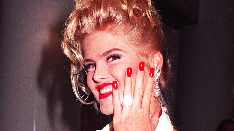Anna Nicole Smith showing off her wedding ring in a white dress
