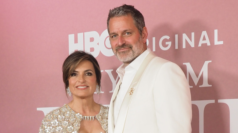 Mariska Hargitay smiling in an embellished silver jacket beside husband Peter Hermann