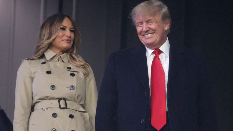 Melania Trump smiling while Donald Trump laughs