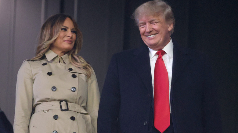 Melania Trump smiling while Donald Trump laughs